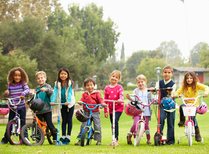Young Children With Bikes And Scooters In Park